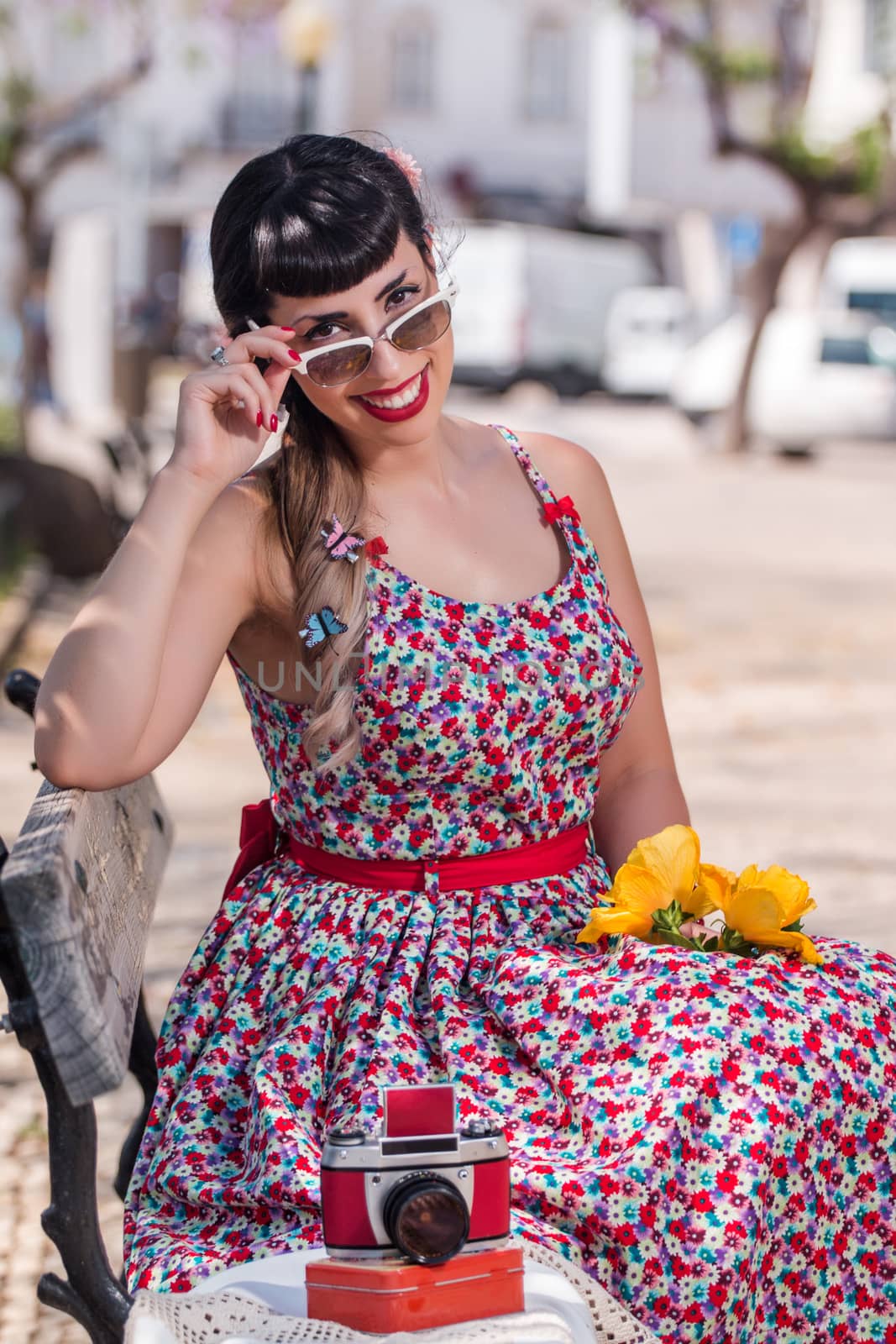 Pinup girl  with dress relaxing in the beautiful urban park.