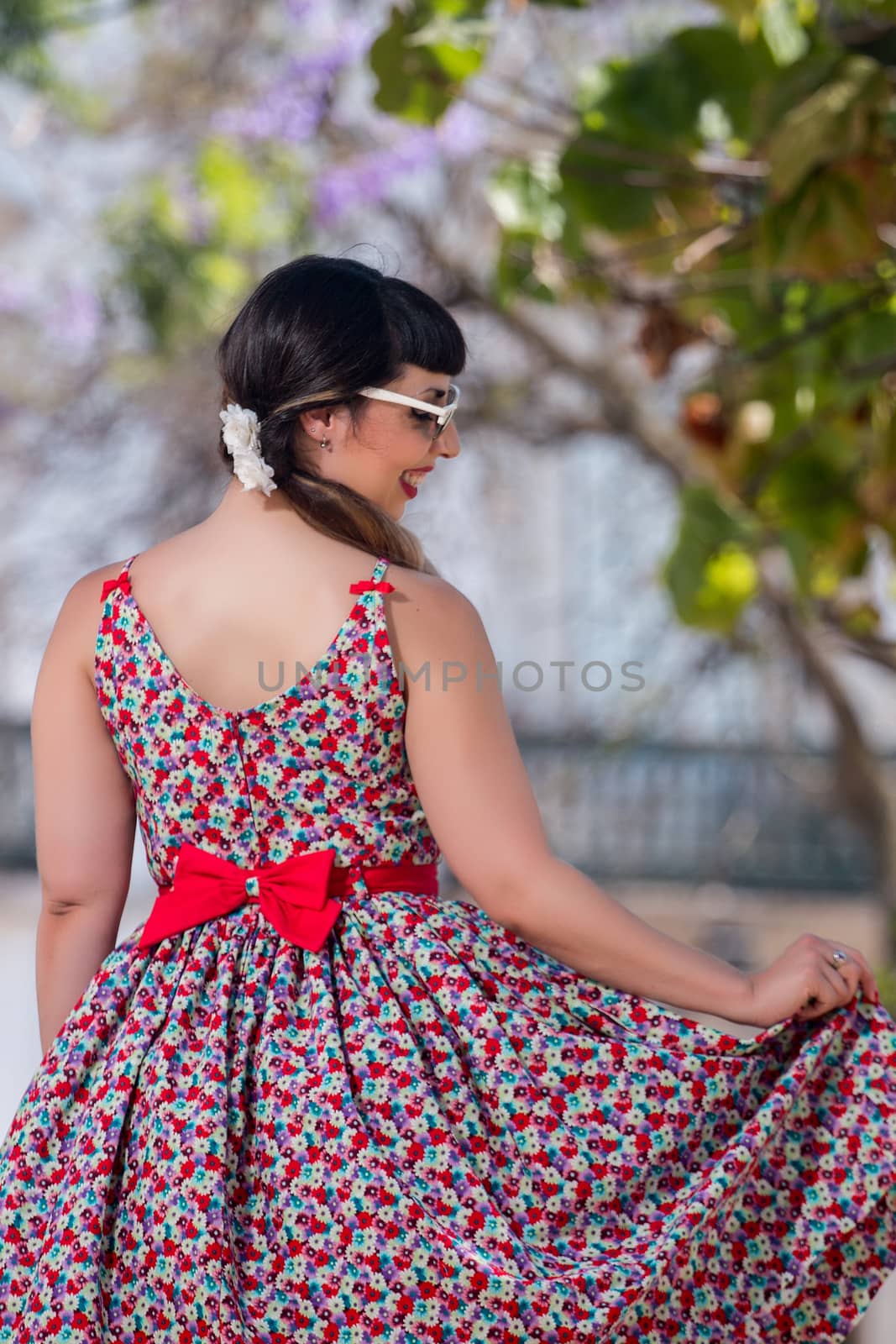 Pinup girl  with dress relaxing in the beautiful urban park.