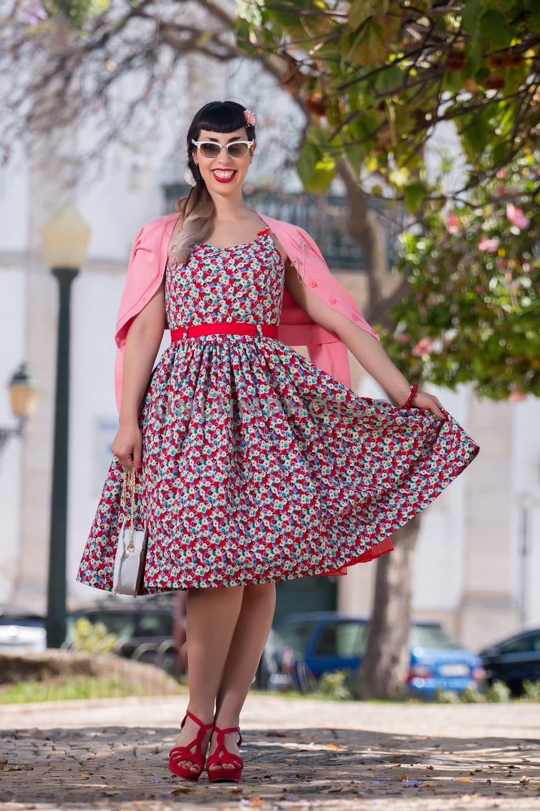 Pinup girl  with dress relaxing in the beautiful urban park.