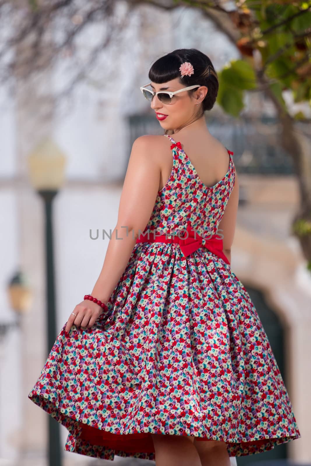 Pinup girl  with dress relaxing in the beautiful urban park.