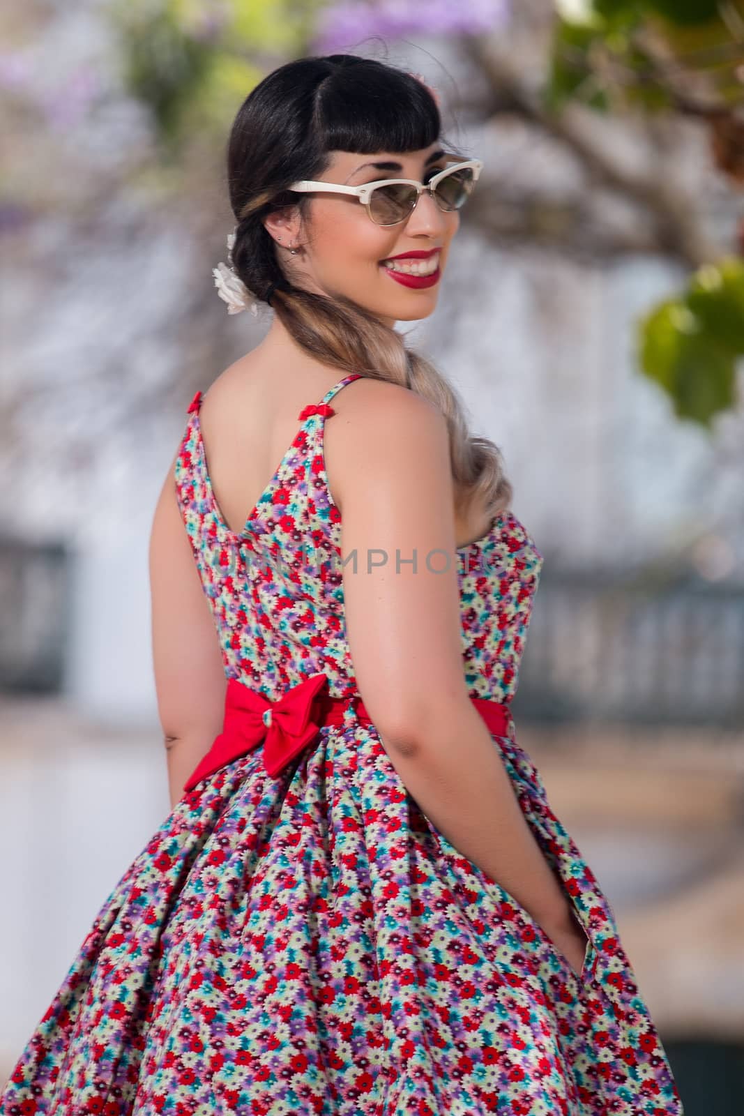 Pinup girl  with dress relaxing in the beautiful urban park.