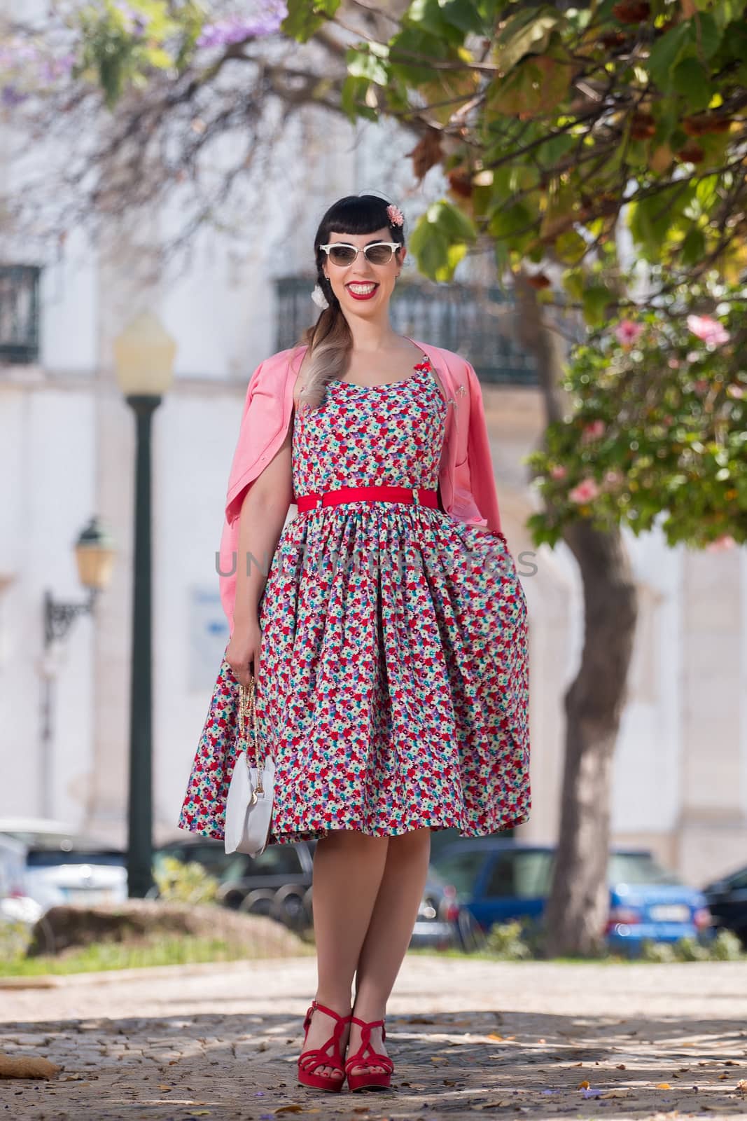 Pinup girl  with dress relaxing in the beautiful urban park.