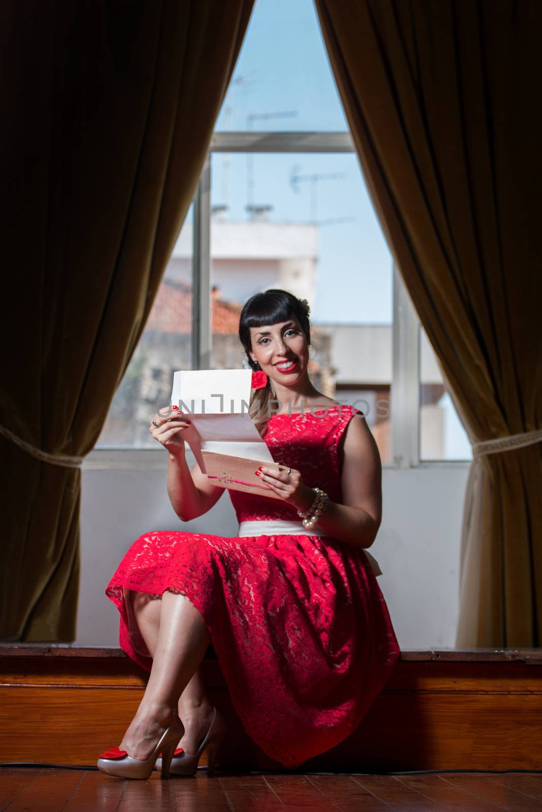 Pinup girl with red dress reading a romantic letter.