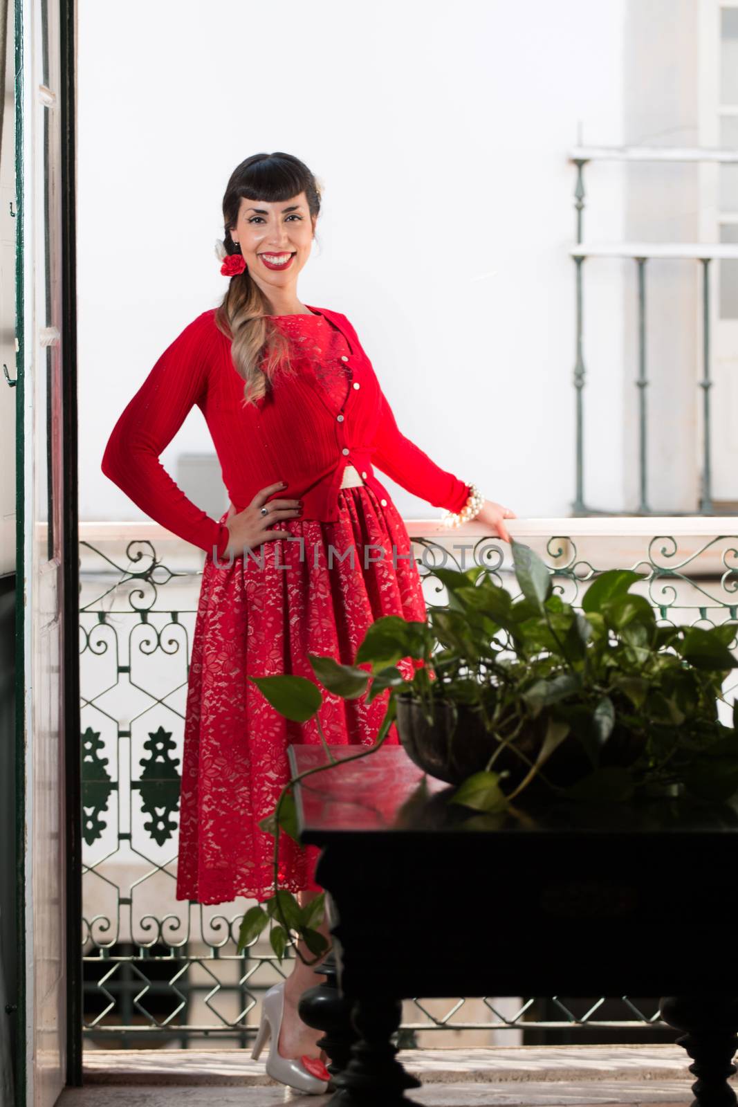 Pinup girl with red dress next to a classic window.