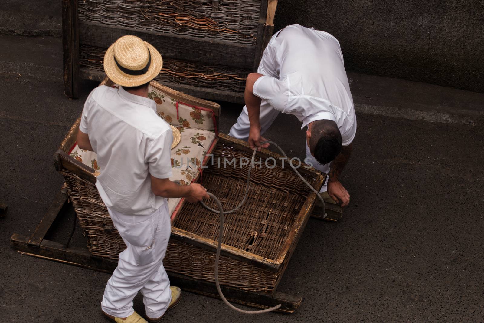 Traditional toboggan man operating a wicker basket car.