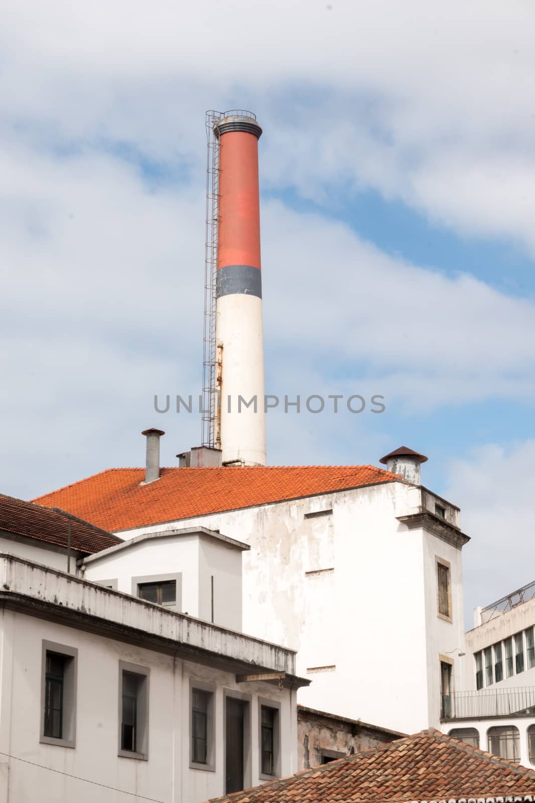 View of a tall factory red chimney in Funchal, Madeira.
