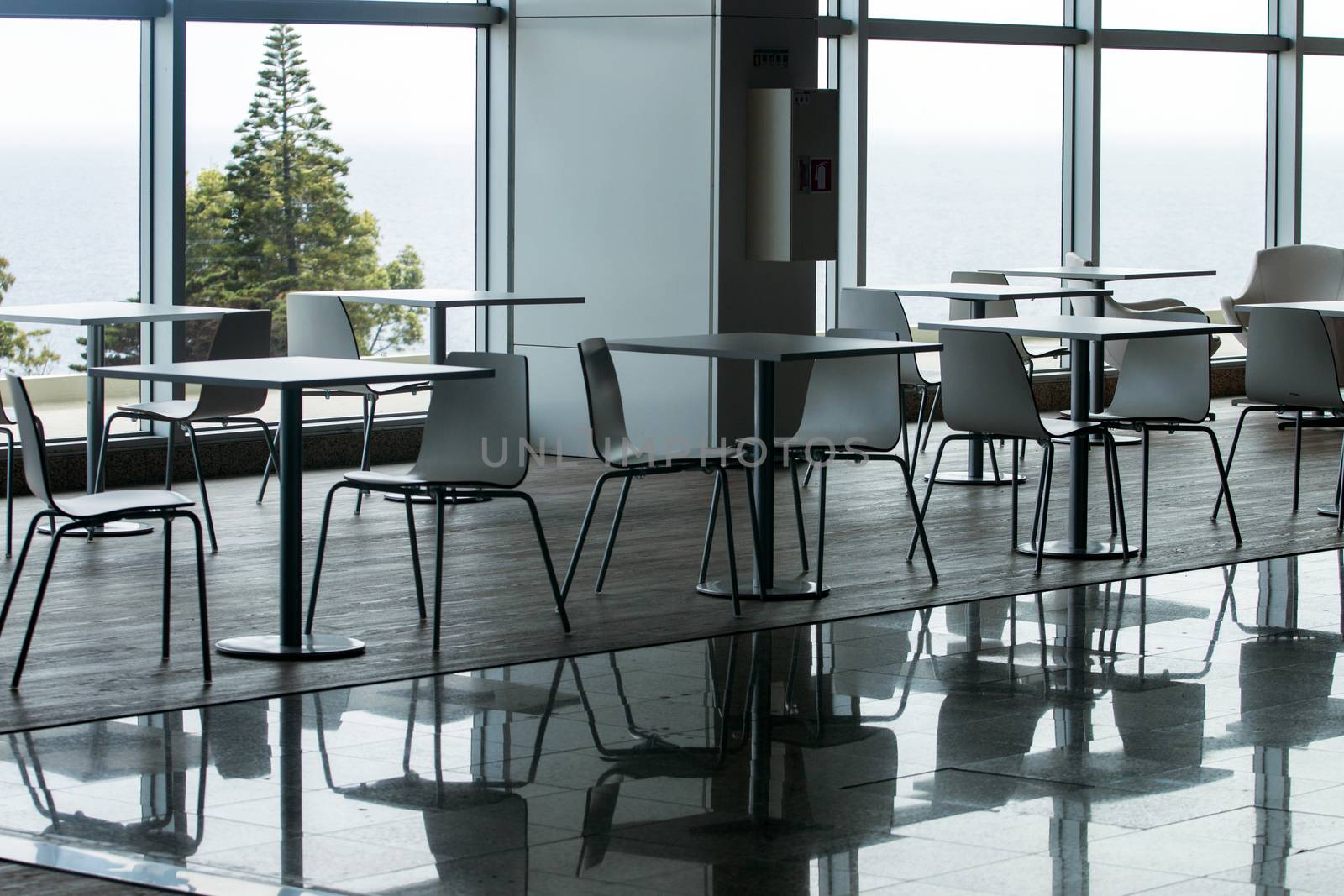 View of several white waiting room chairs and tables.