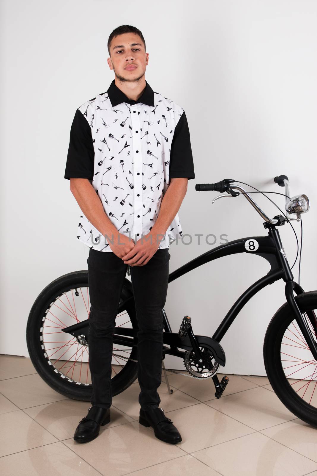 Teenager posing with a vintage style retro clothing and a bike.