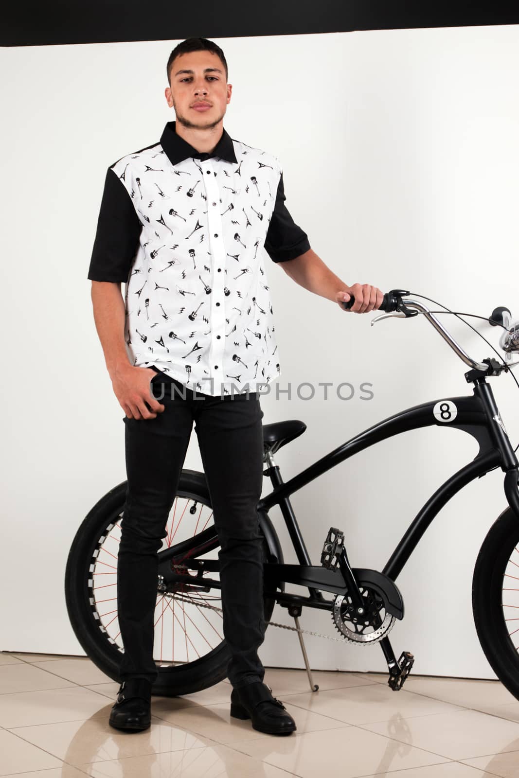 Teenager posing with a vintage style retro clothing and a bike.