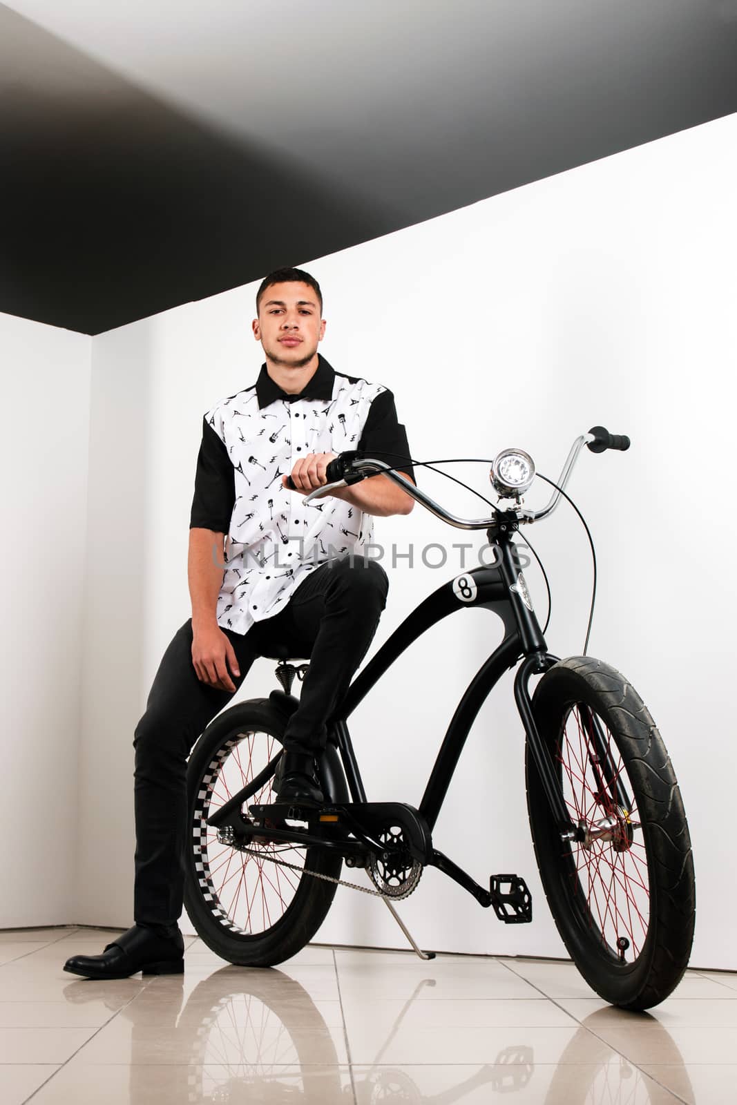 Teenager posing with a vintage style retro clothing and a bike.