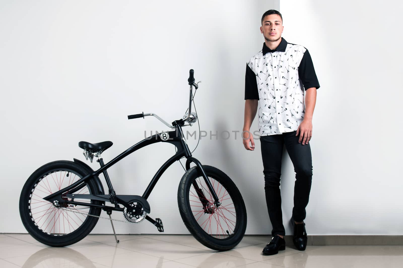 Teenager posing with a vintage style retro clothing and a bike.