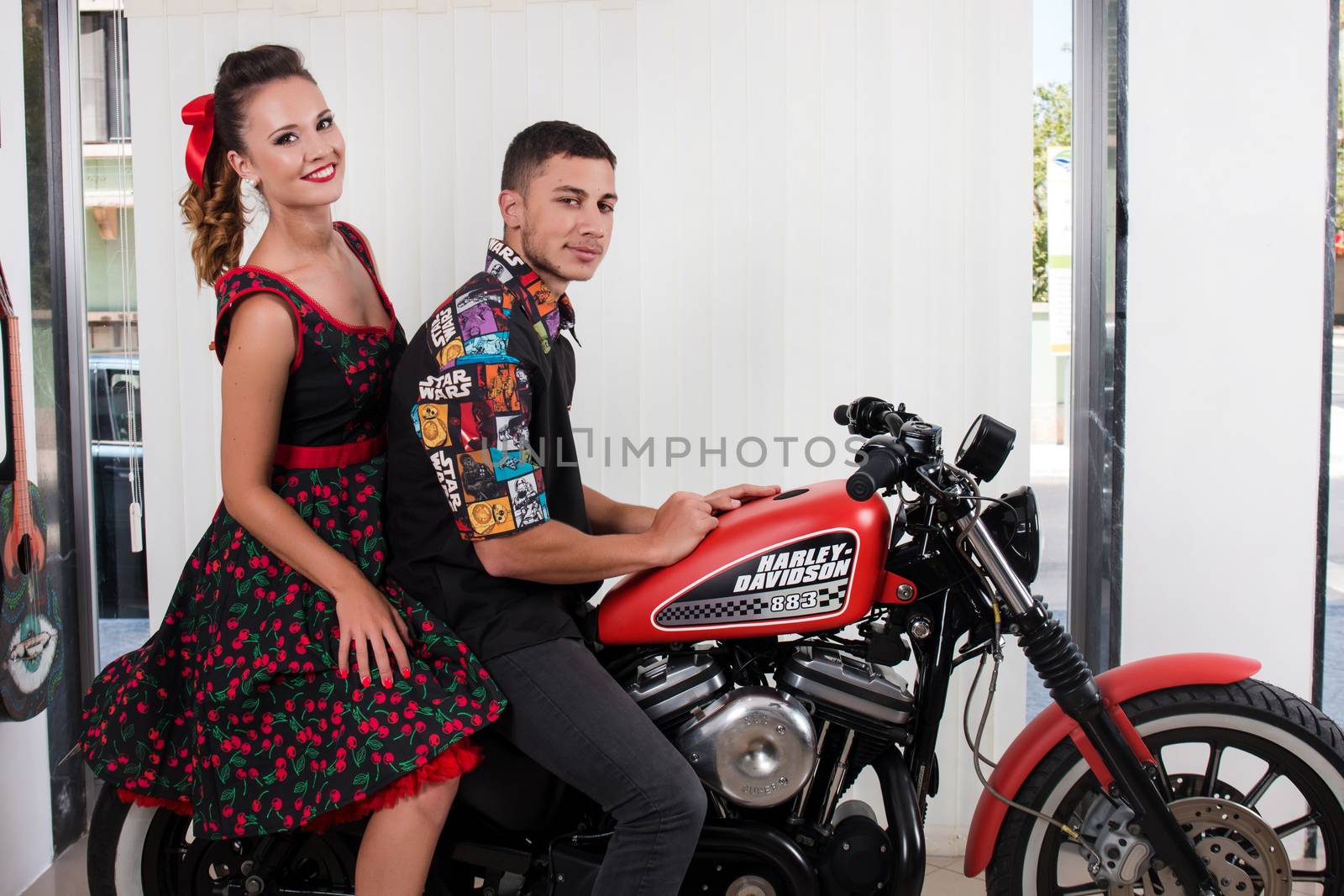 Close up of a couple using vintage clothing on a motorbike.