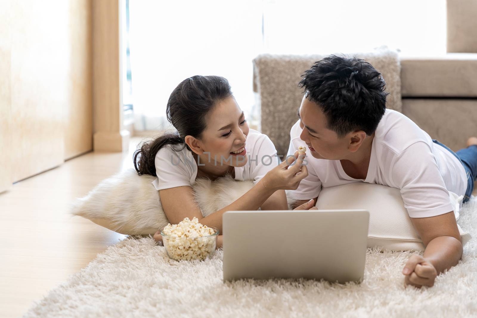 Young Asian Couples using laptop together in bedroom of contemporary house for modern lifestyle concept