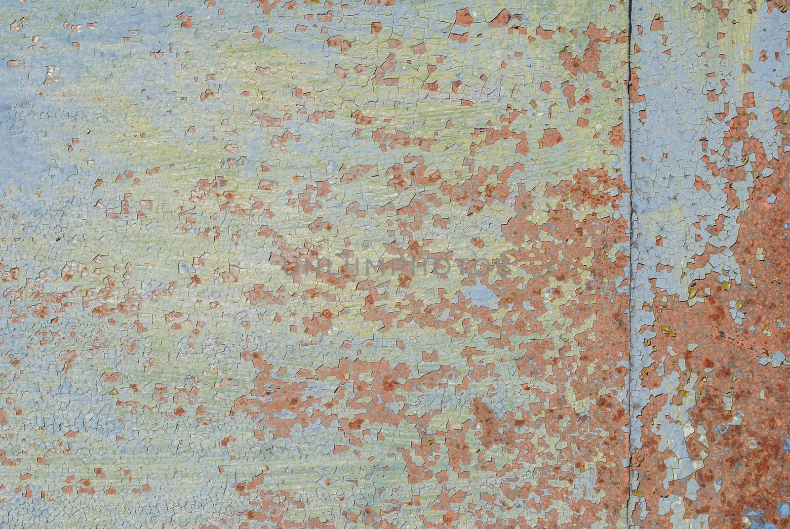 fragment of a rusty iron surface covered with old paint, which has long been under the influence of different climatic conditions