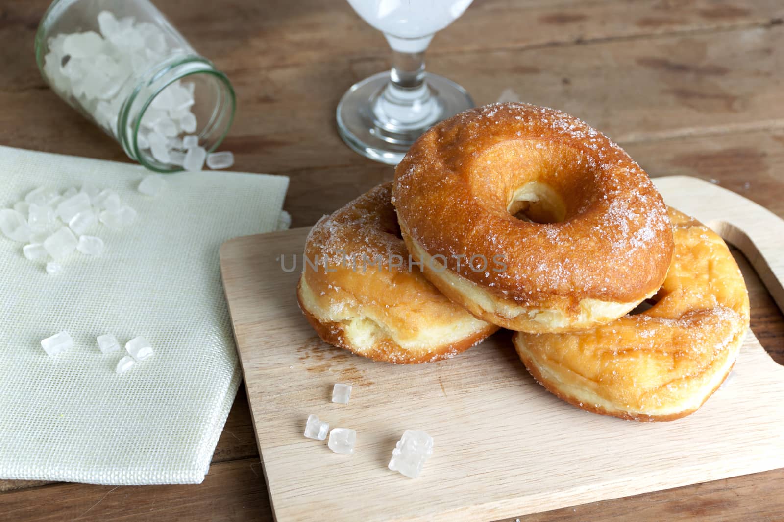 donuts glazed with a sugar icing on a rustic wooden table