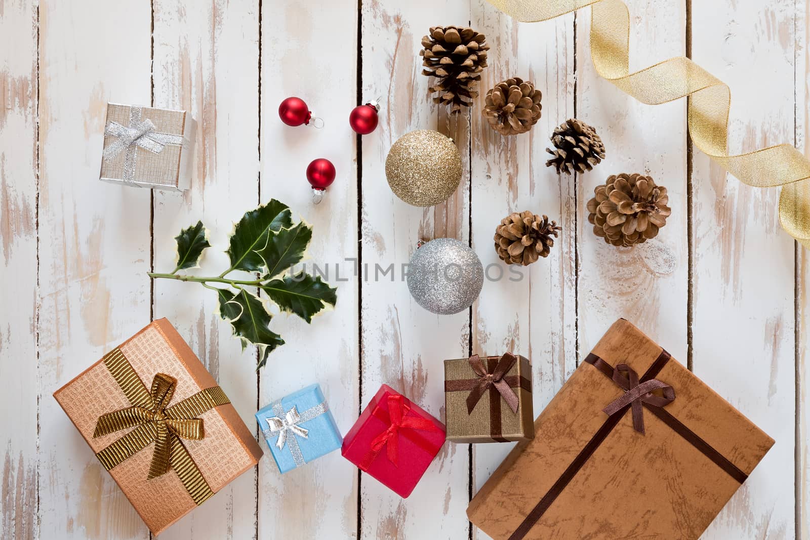 Christmas presents and decorations over a rustic wooden table seen from above