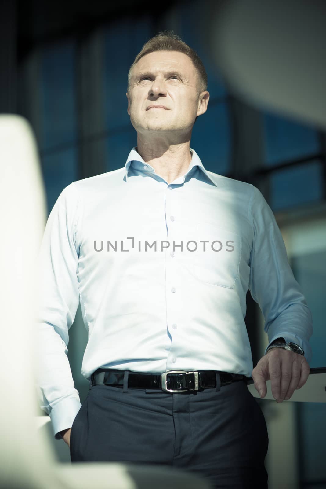 Portrait of serious mature businessman standing in cafe of office building