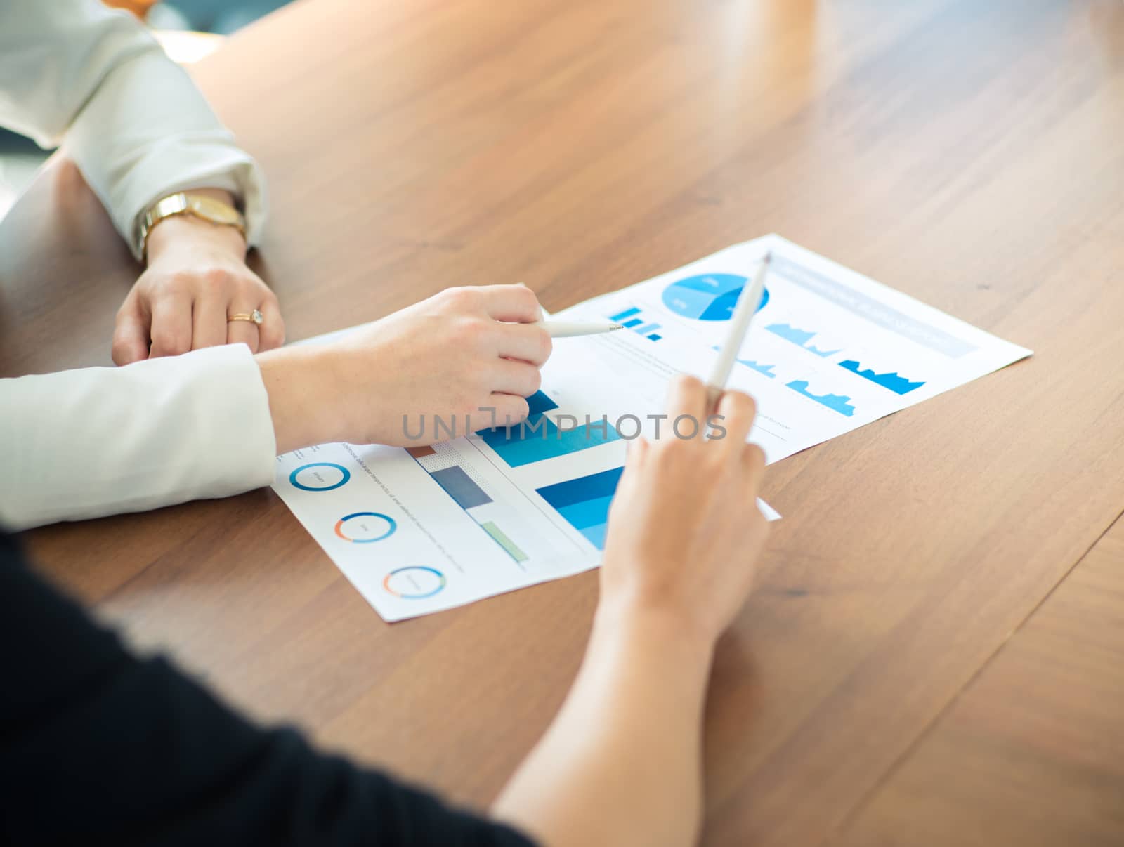 Business people pointing at diagrams discussing financial reports at workplace