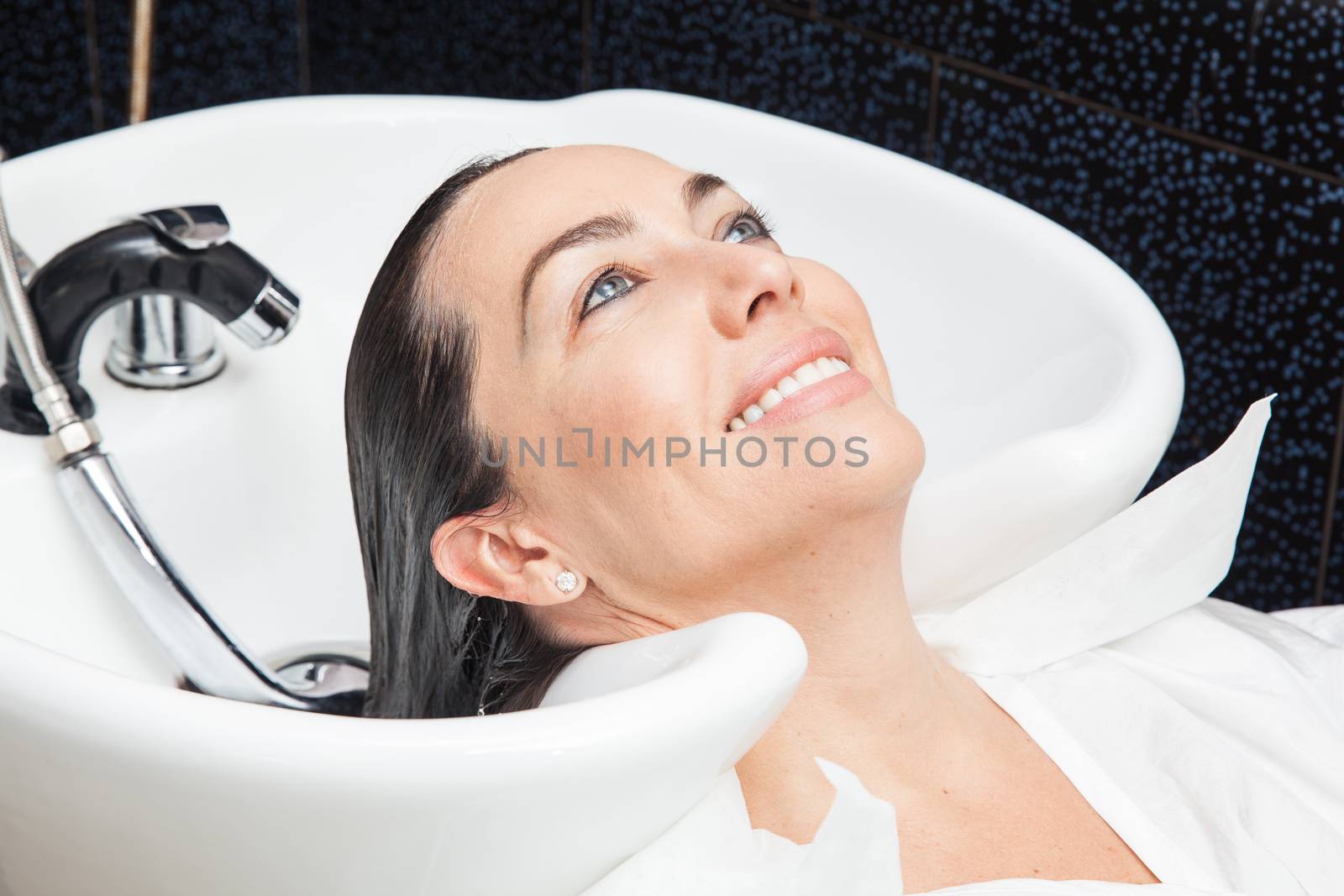 White woman getting a hair wash procedure in a beauty salon