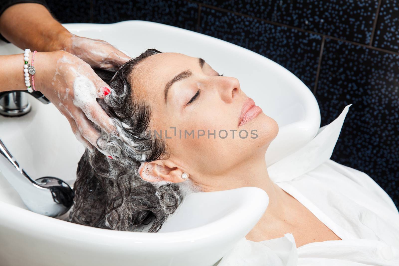 White woman getting a hair wash procedure in a beauty salon