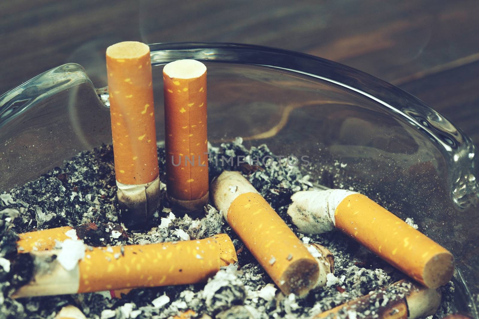 Tobacco cigarettes ashtray and smoke.