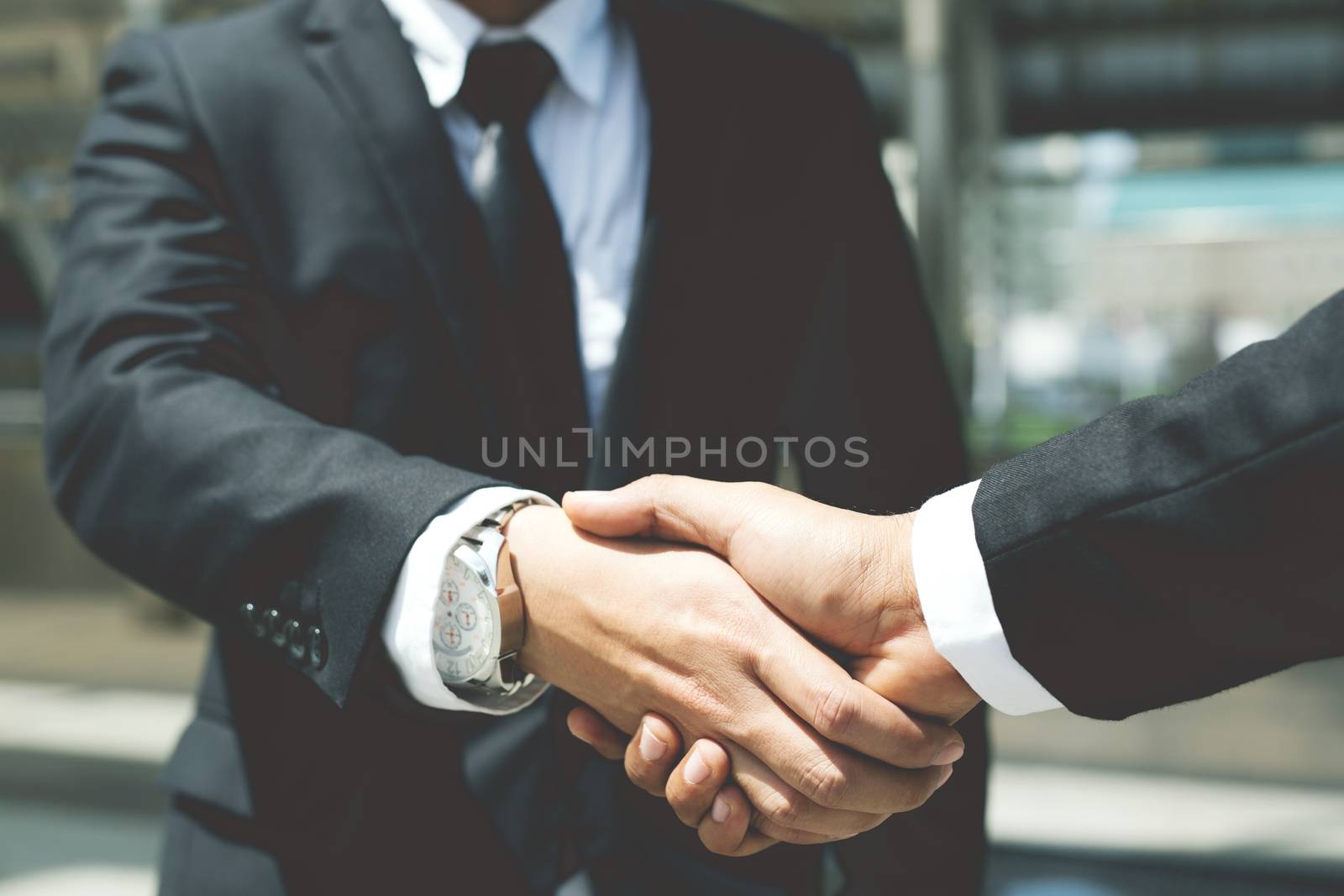 Closeup of a businessman hand shake between two colleagues OK, succeed in business.