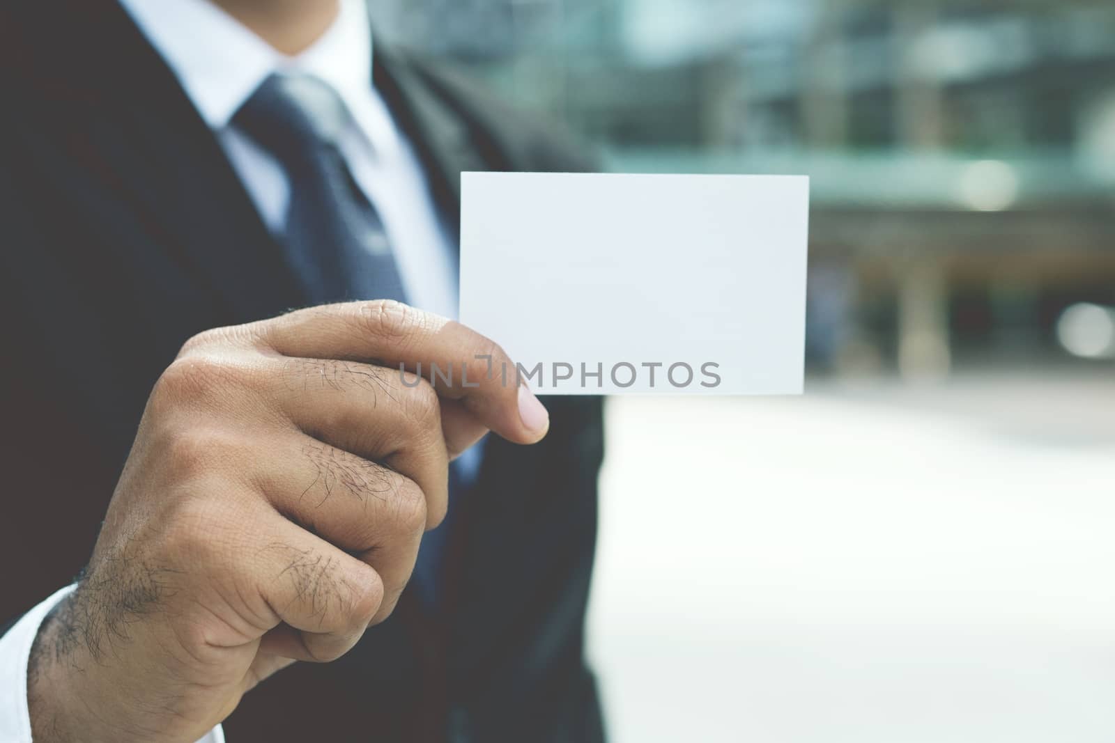 Young businessman who takes out blank business card from the pocket of his shirt business suit, copy space