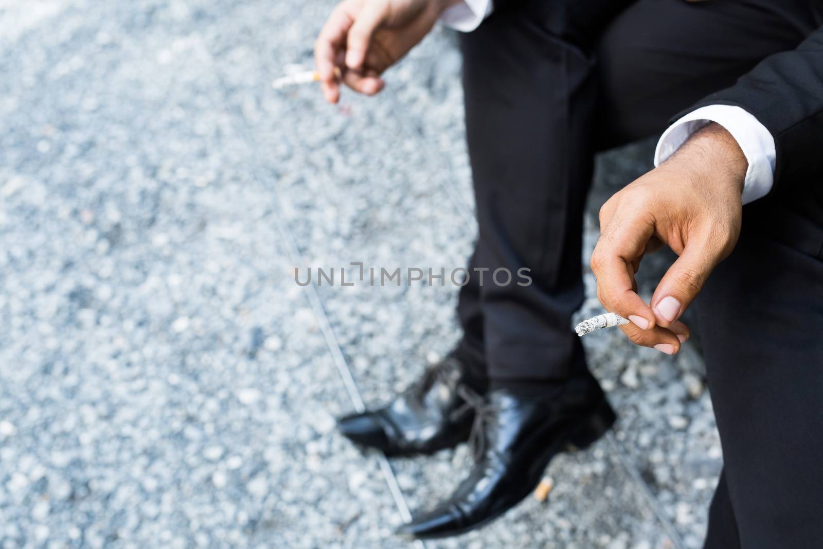 businessman two person cigarettes for smoking sit in the smoking zone area.