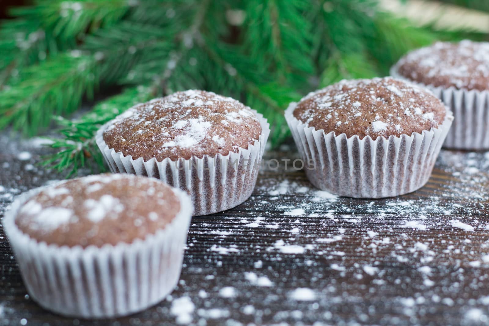 Christmas and New Year winter holiday composition of three cakes on snowbound wooden space background with green fir tree branches