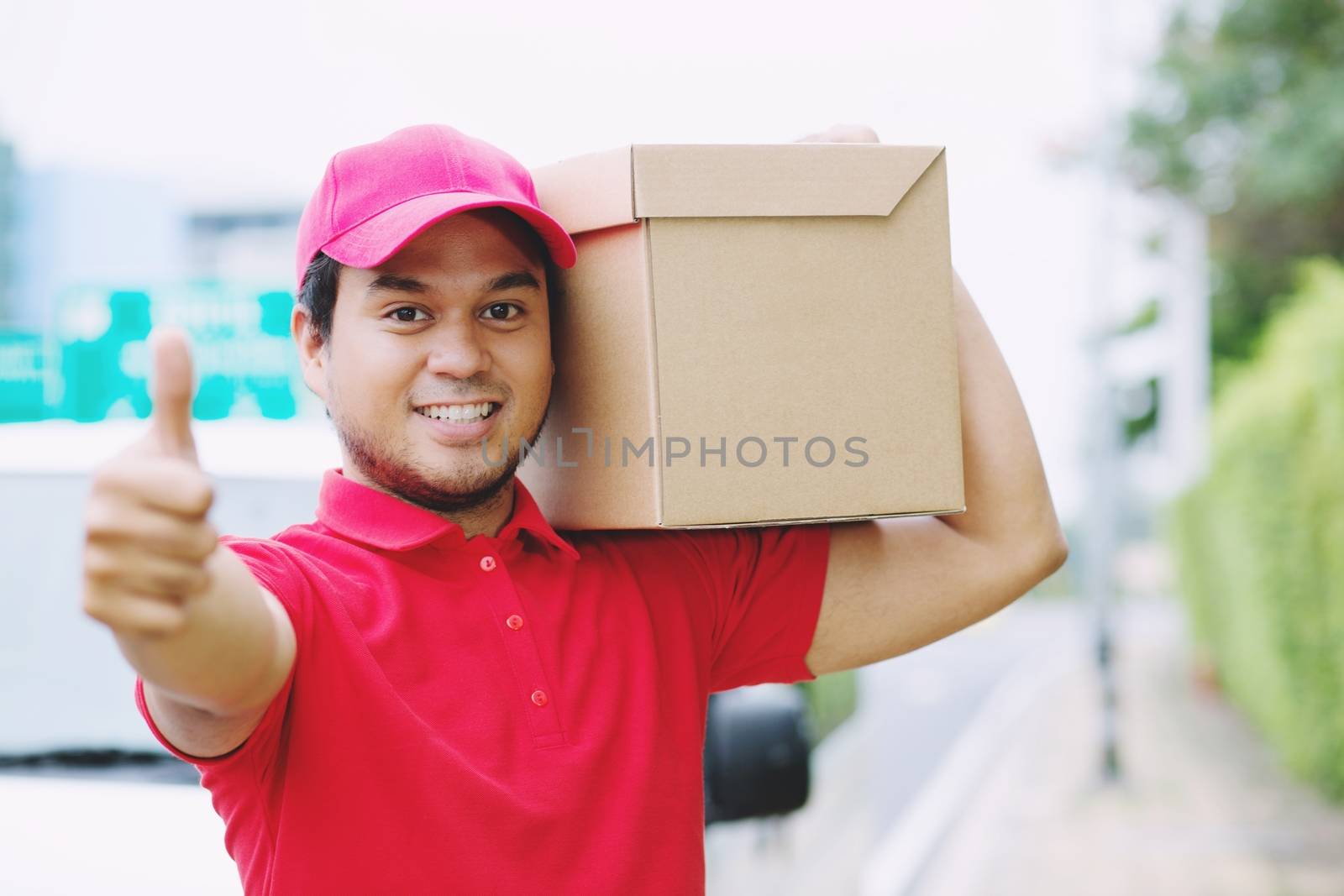 delivery service courier ringing the house doorbell with boxes in hands