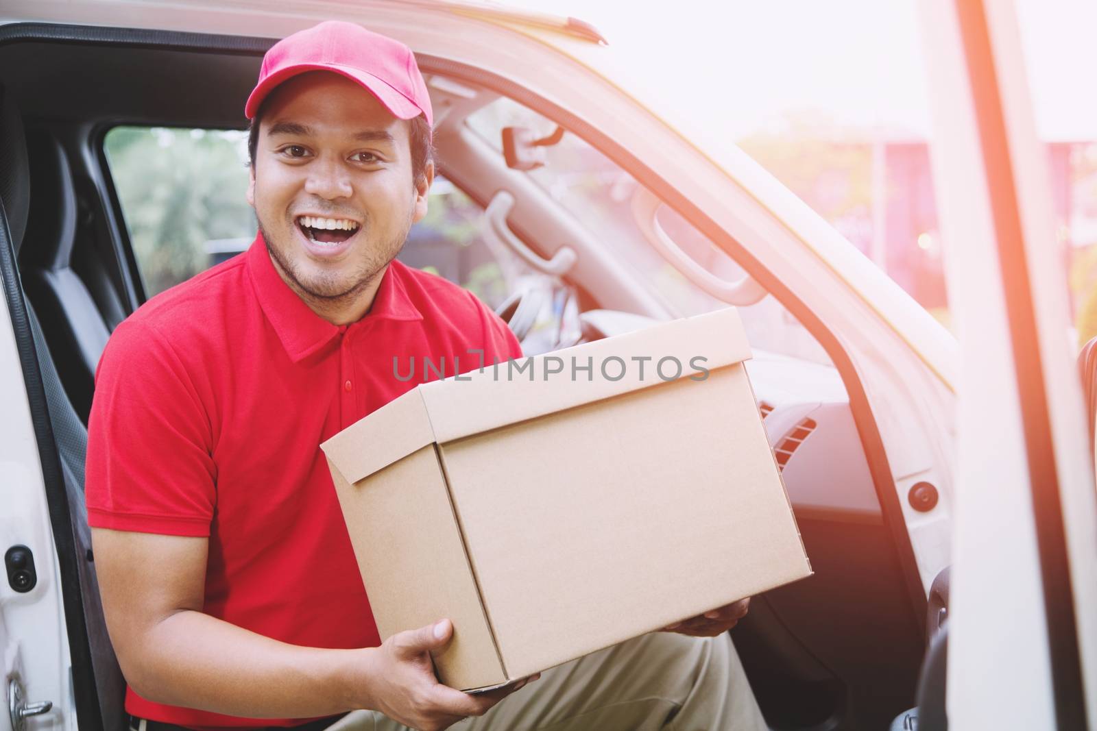 delivery service courier ringing the house doorbell with boxes in hands