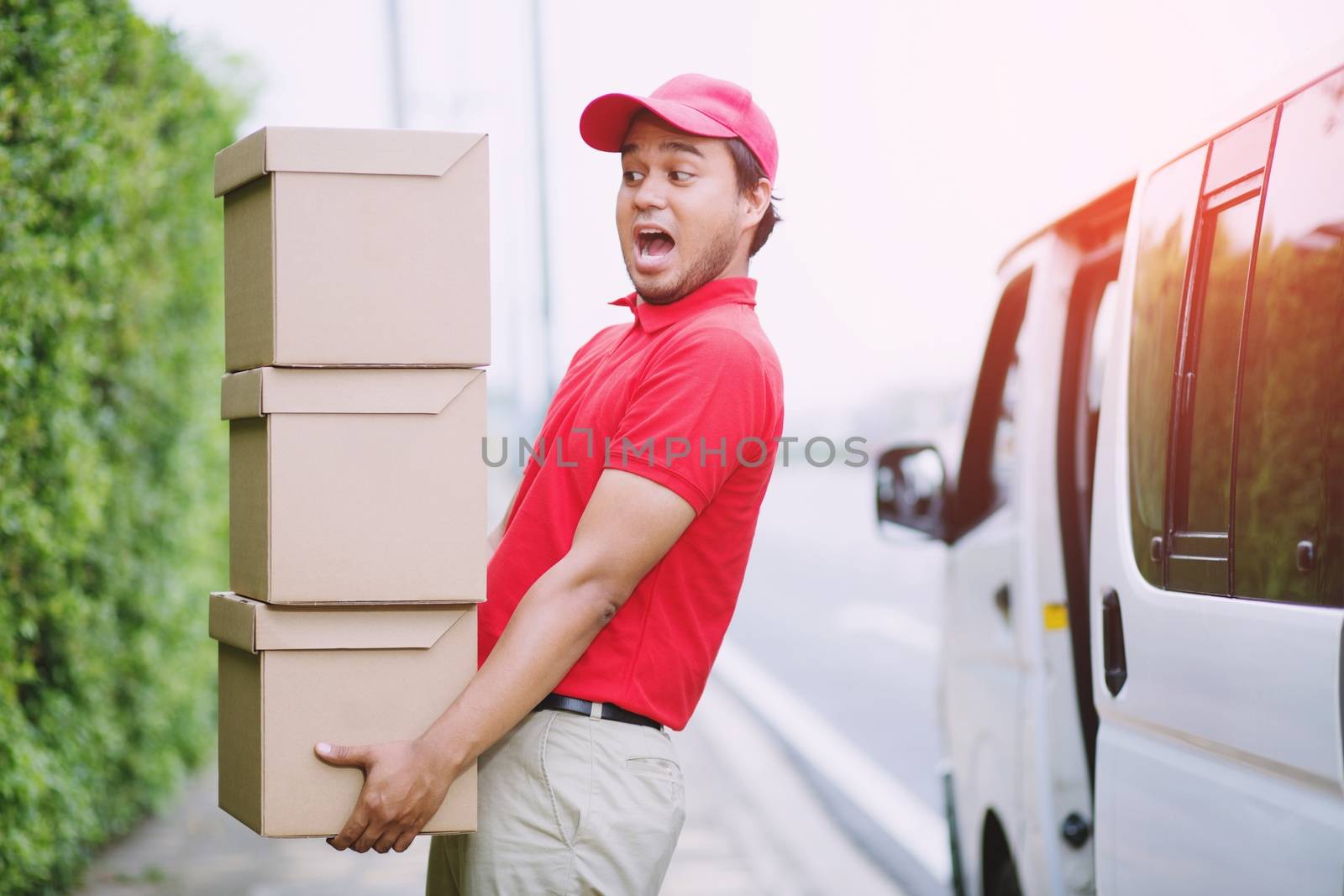 delivery service courier ringing the house doorbell with boxes in hands