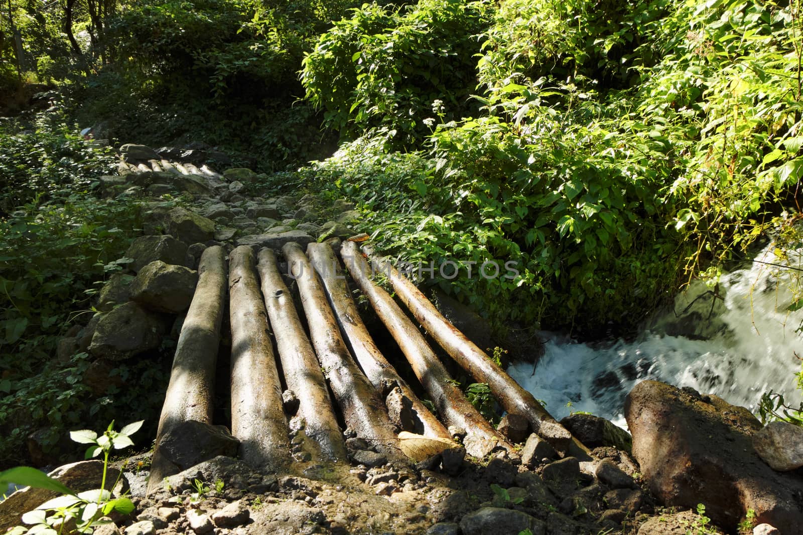 A small wooden bridge across a mountain stream in Nepal