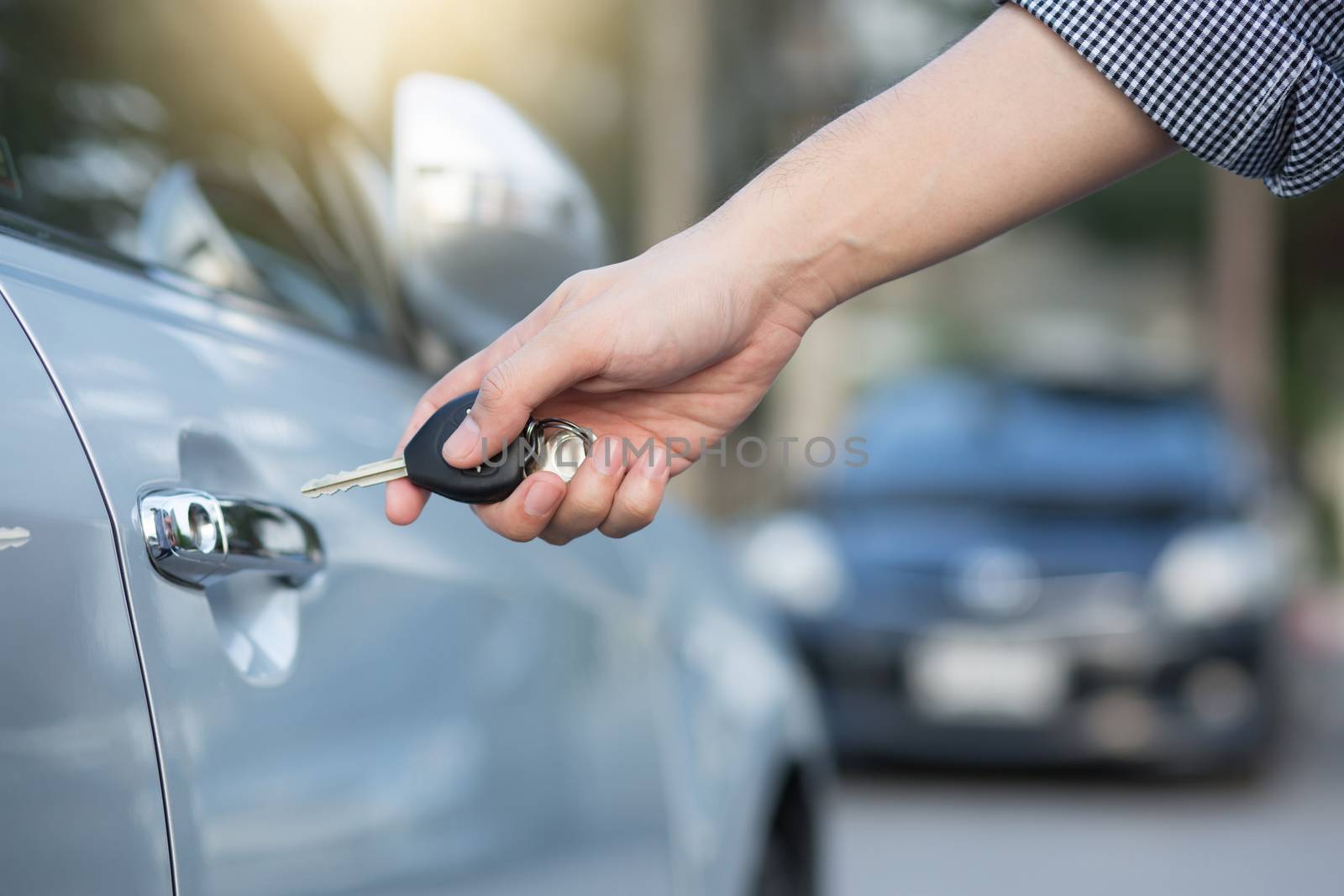 Cropped view of Closeup of a man's hand inserting key into the door lock of a car
