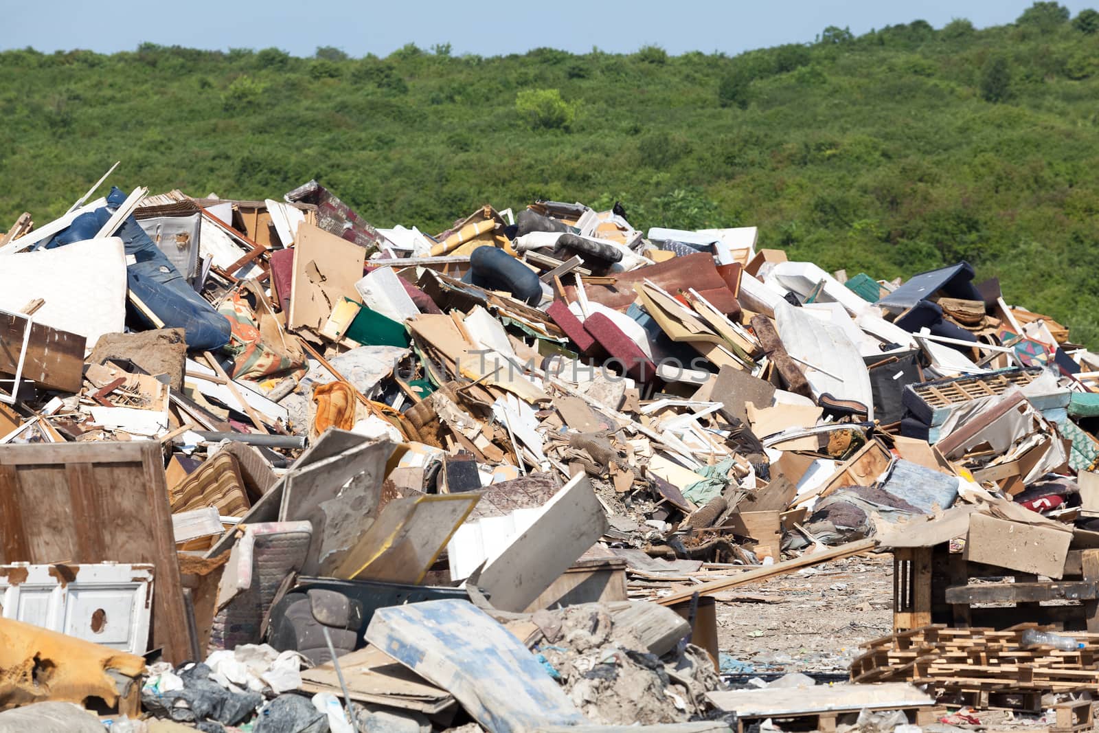 Old furniture at the landfill in focus, nature in the background