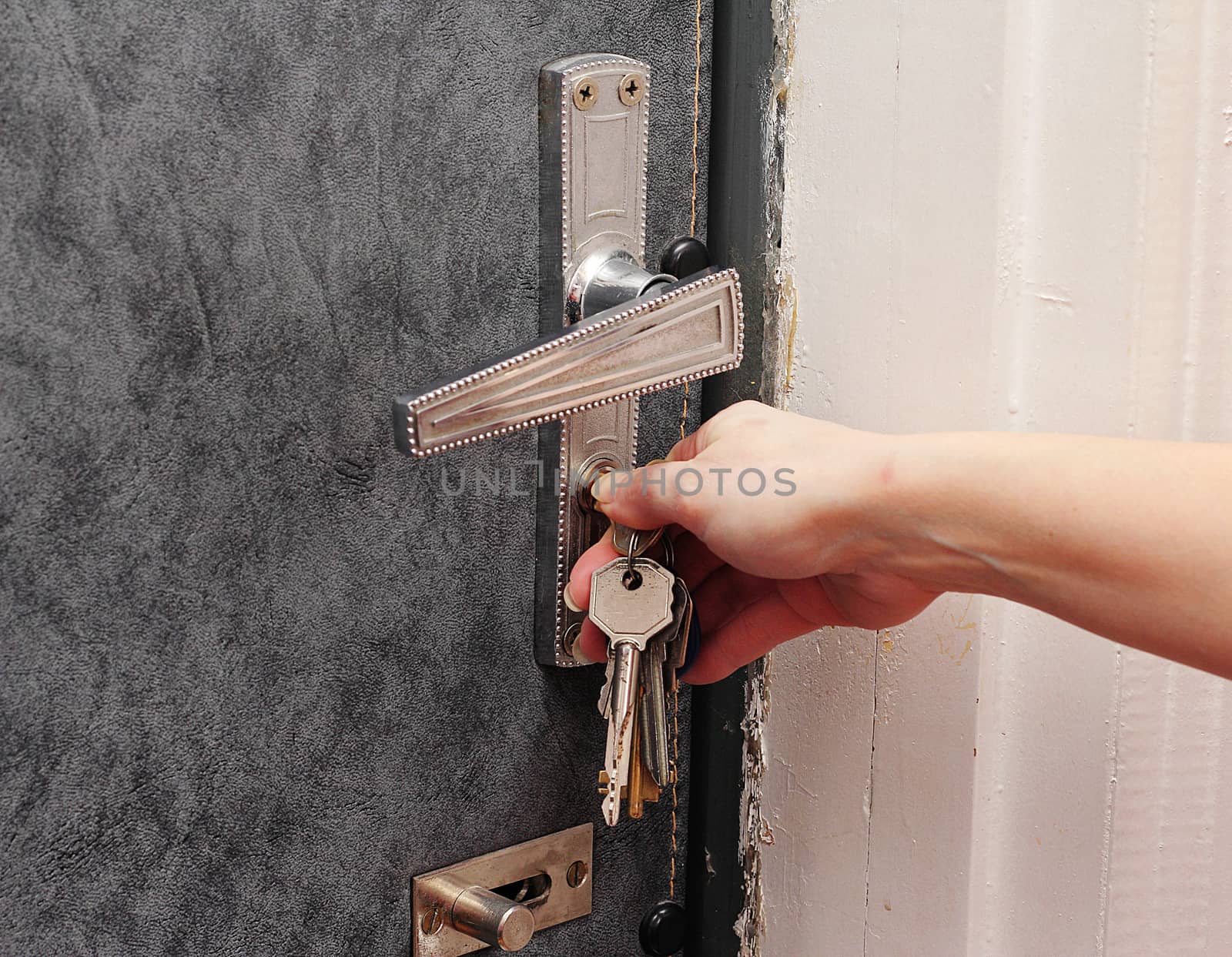 Female hand open the metal door key.