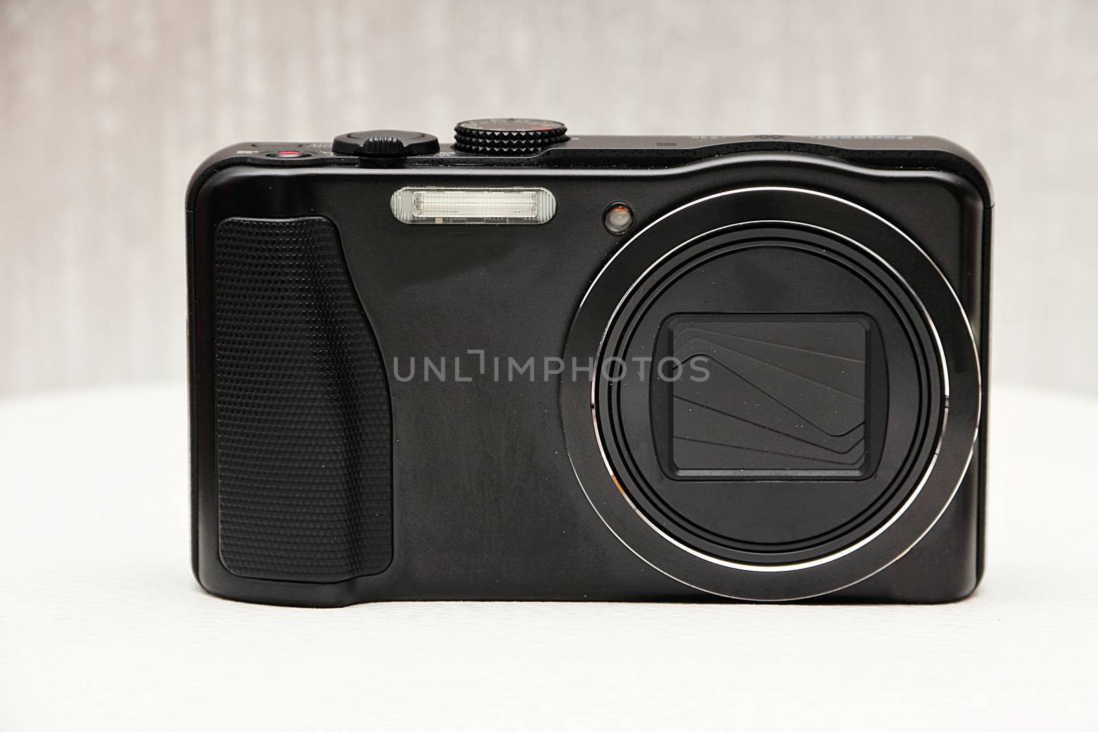 Compact modern digital camera on a neutral background.