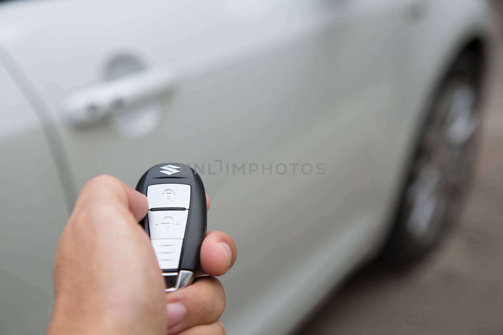 Woman with car key in hand presses on the remote control car alarm systems.