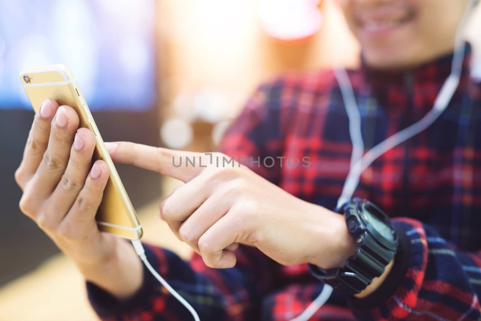 the tourist young man traveler with backpack stand in public electric train look at the he hand use the phone to check travel at the station.Travel concept.