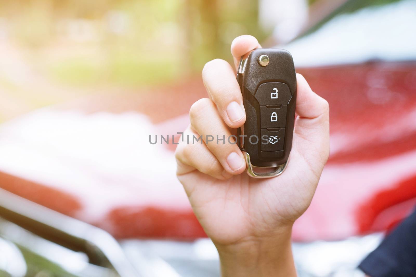 lady female holding car keys with car on background.