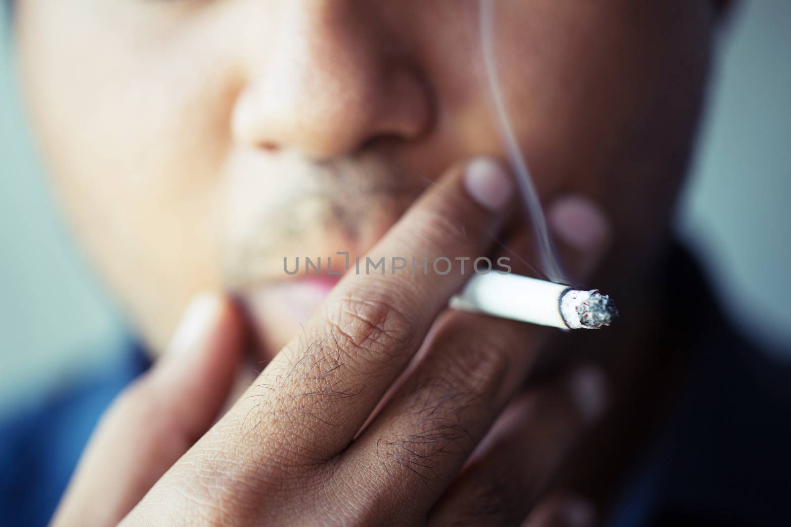 man smoking a cigarette. Cigarette smoke spread