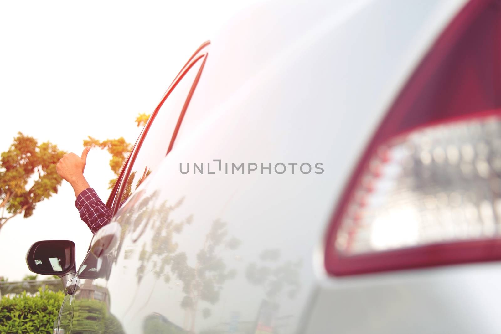 Man traveler ready to leave drive a car on the road. showing hand thumb up outdoor.