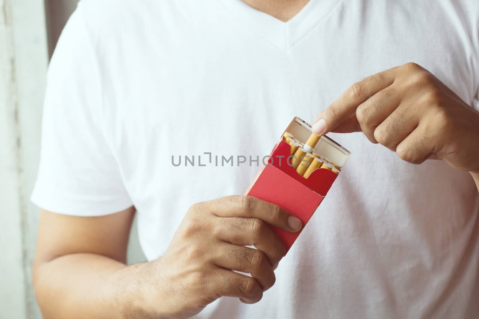 Man is picking Cigarette from Package come up smoking.