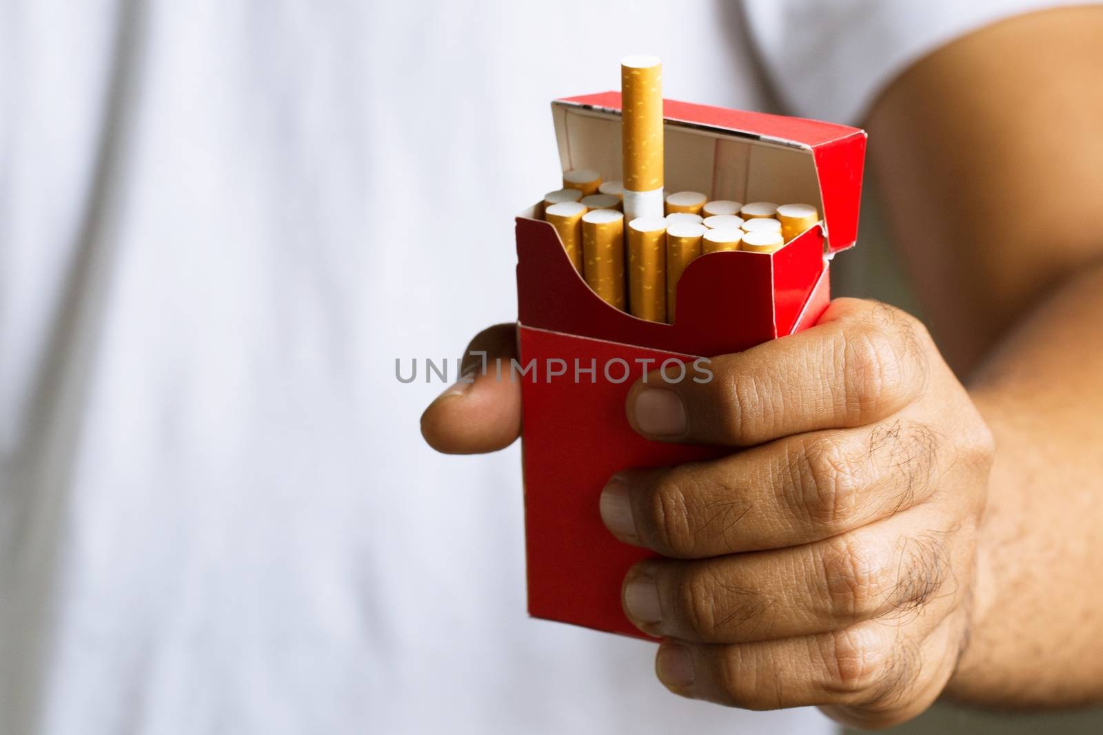 Man is picking Cigarette from Package come up smoking.