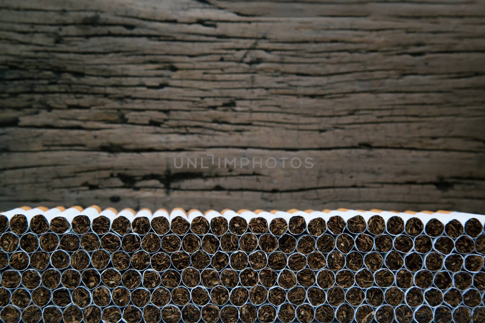 Stack Tobacco Cigarettes with wooden background in vintage retro color. by boytaro1428@gmail.com