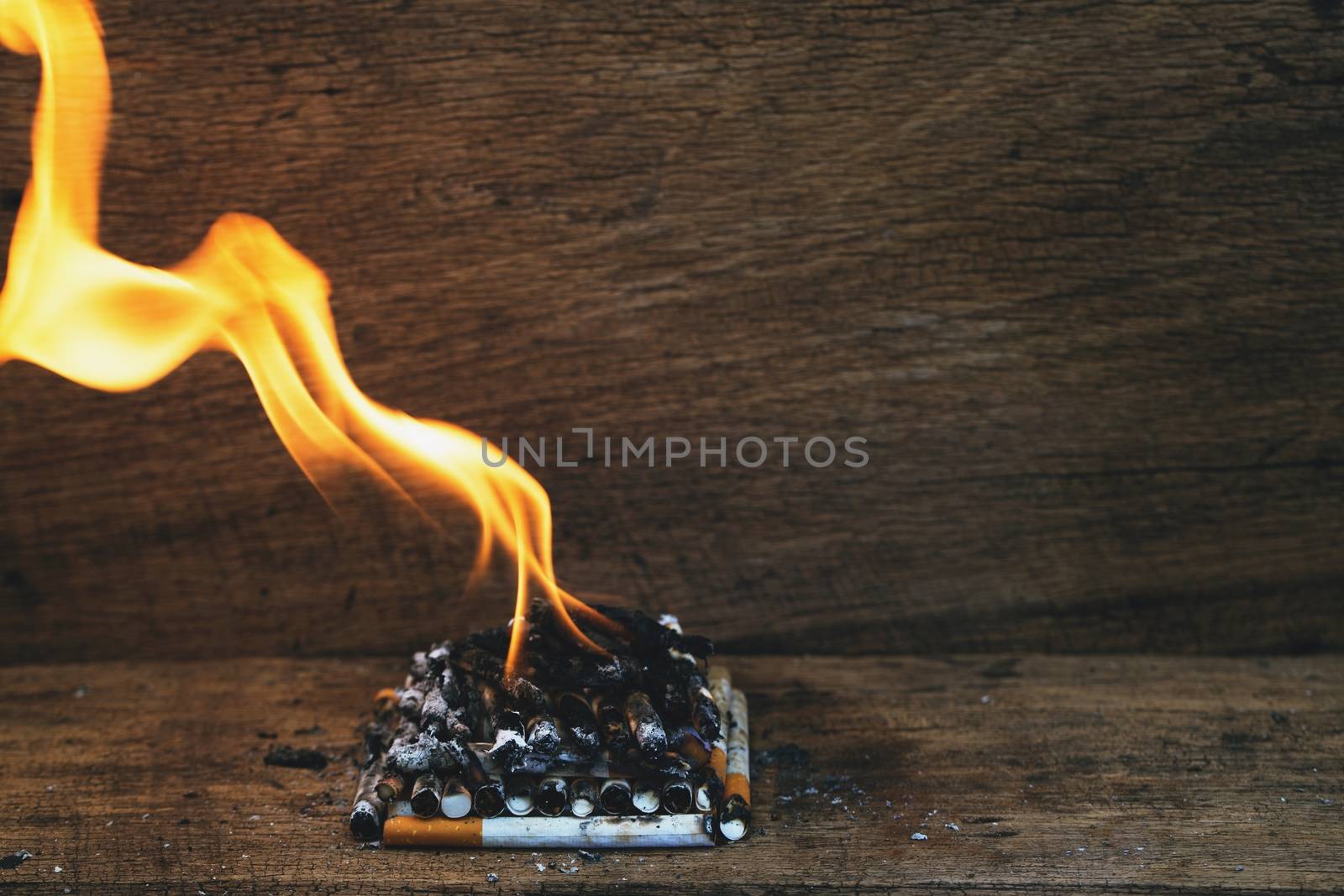 burning cigarette In the wood floor. Campaign no smoking concept. by boytaro1428@gmail.com