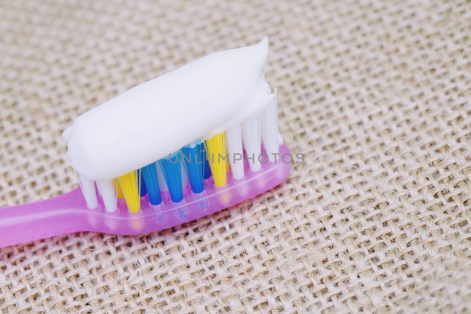 Toothbrush with toothpaste on a sackcloth background by boytaro1428@gmail.com