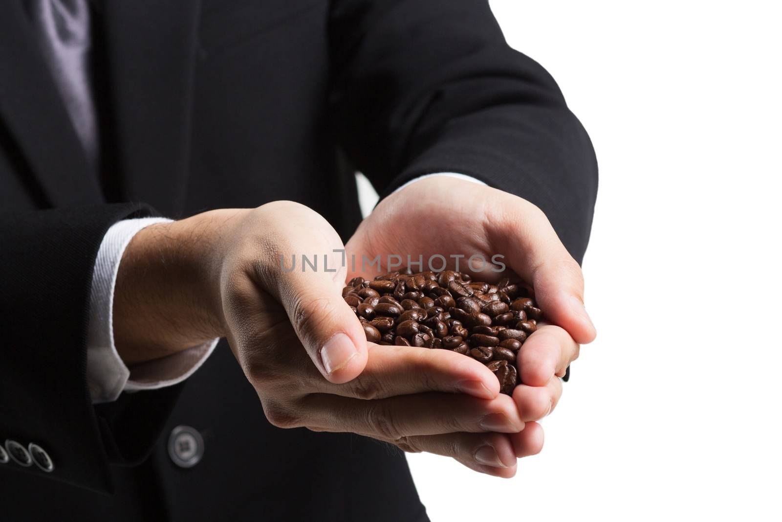 Coffee beans in hands on white background