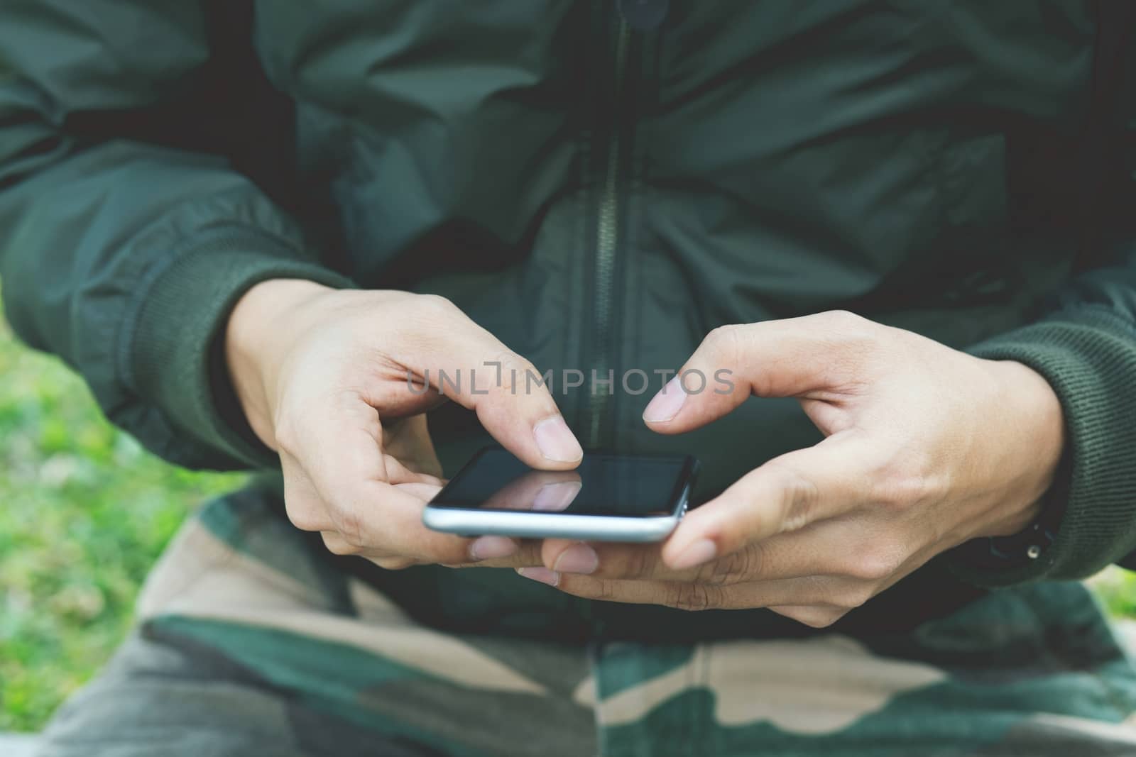 close up of Man Soldier plainclothes using mobile smart phone.