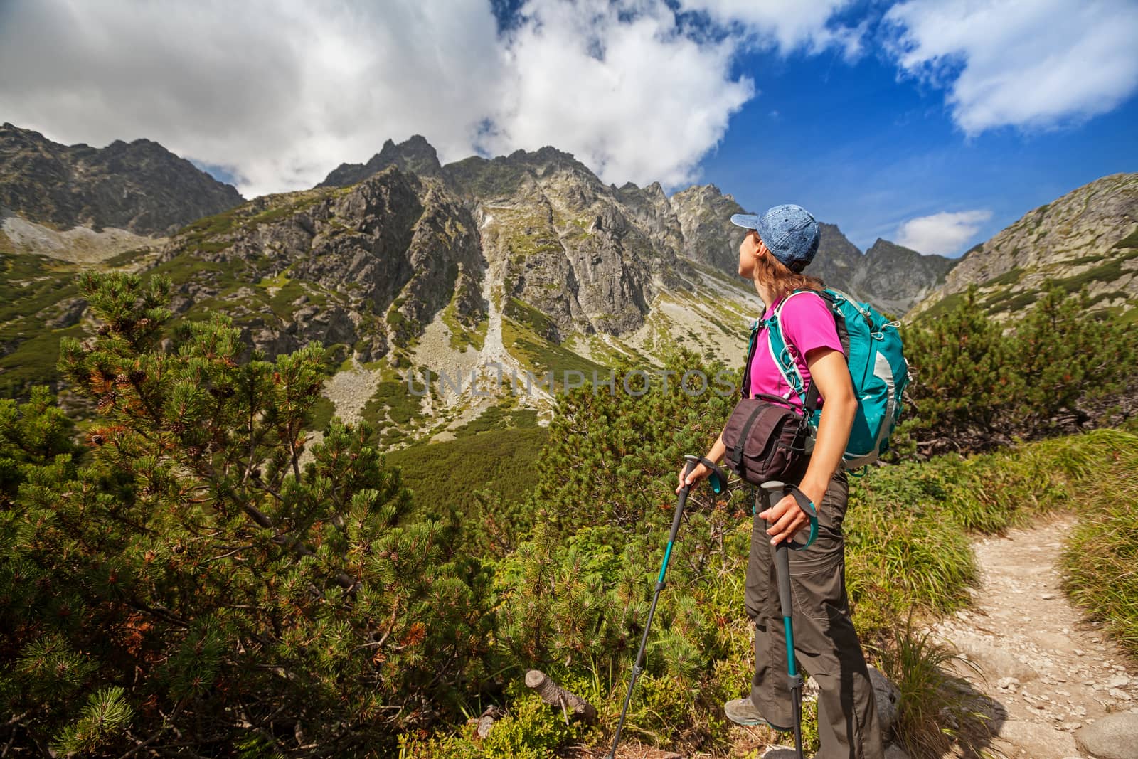 Hiking woman admiring the beauty of rocky mountains by igor_stramyk